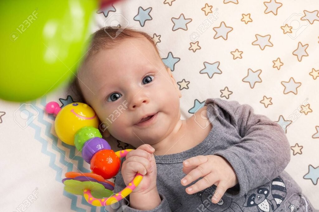 bebe feliz jugando con juguete colgante