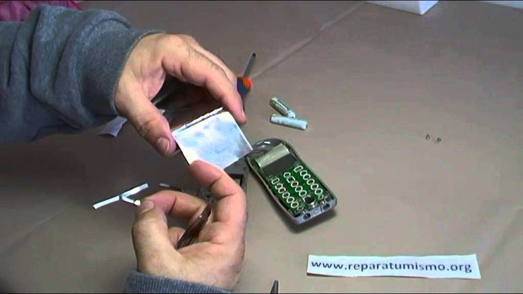 manos reparando un teclado de celular