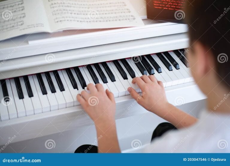 manos tocando un piano con partituras