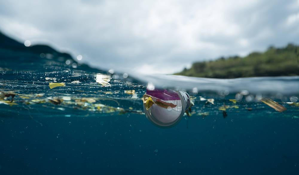 olas del mar con residuos plasticos flotando