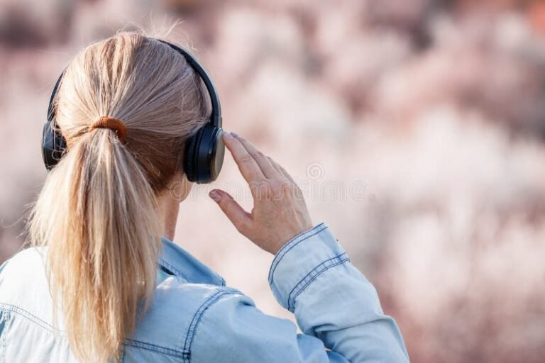 Qué canción suena en mi reproductor, cómo la identifico 19 persona usando auriculares en un paisaje